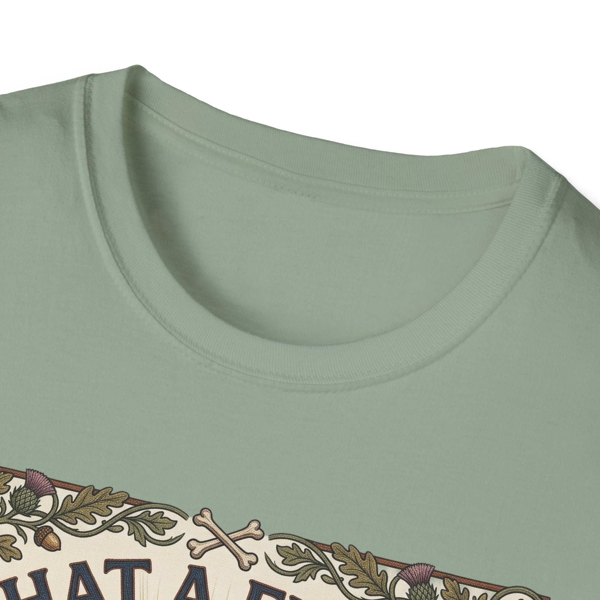 What a Friend We Have in Dog T-Shirt close-up detail shot on a sage green shirt, showing the vintage botanical border with crossbones and floral motifs at the neckline.