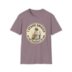 I Stand Amazed Great Dane T-Shirt flat lay in dusty mauve purple, featuring a circular vintage-style graphic of a towering Great Dane with a halo and a small human figure, with text "I Stand Amazed in the Presence of Dog."