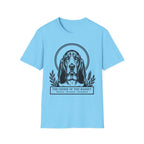 Holy Orders | Basset Hound T-Shirt flat lay on navy shirt featuring a stained glass style illustration of a Basset Hound depicted as a holy figure with a golden halo and the text 'Holy Orders.'