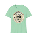 Believe in the Power of Dog Paw T-shirt flat lay in mint green, featuring a circular vintage badge graphic of a dog paw raised like a fist from clouds above crossed bones, with paw print accents and bold text.
