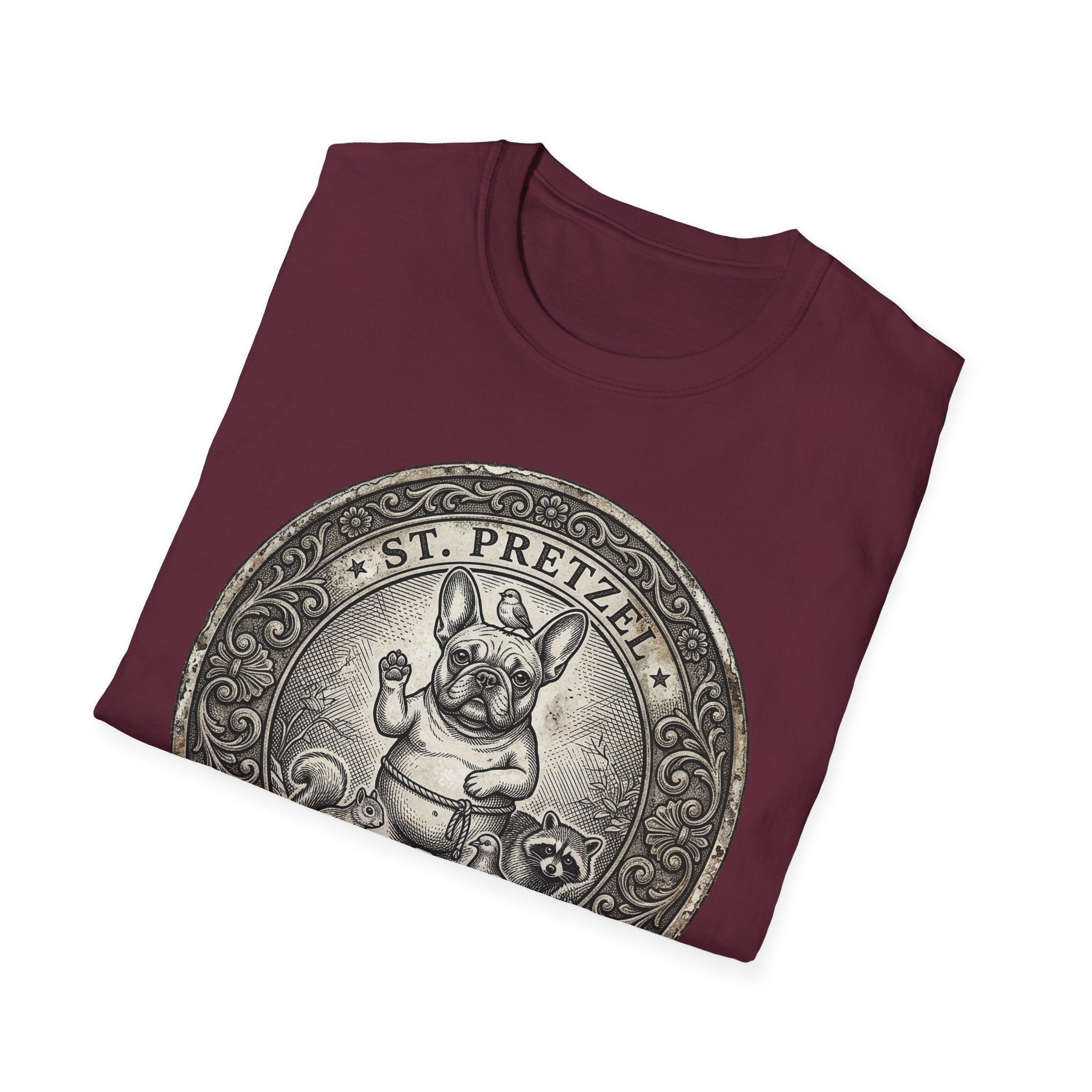 Saint Pretzel Forgive Us T-Shirt folded flat lay on maroon shirt showing the St. Pretzel French Bulldog medallion design.