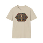 Praise Dog From Whom All Blessings Flow Corgi T-Shirt flat lay in natural tan, featuring an ornate medieval stained-glass style graphic of a regal corgi seated in a jewel-encrusted octagonal frame with gold gothic lettering and dog bone and tennis ball accents.