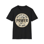 Believe in the Power of Dog Paw T-shirt flat lay in black, featuring a circular vintage badge graphic of a dog paw raised like a fist from clouds above crossed bones, with paw print accents and bold text.