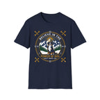 Believe in the Power of Dog Bernese T-Shirt in navy, flat lay view showing a circular badge graphic with a halo-wearing Bernese Mountain Dog set against a mountain and forest landscape, with crossed bones and the words 'Loyalty Warmth Love'.