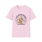 The Joyful Sound of Barking T-shirt flat lay, light pink shirt featuring a circular badge graphic of a cartoon yellow dog with a red bandana howling joyfully with musical notes and the text 'The Joyful Sound of Barking.'