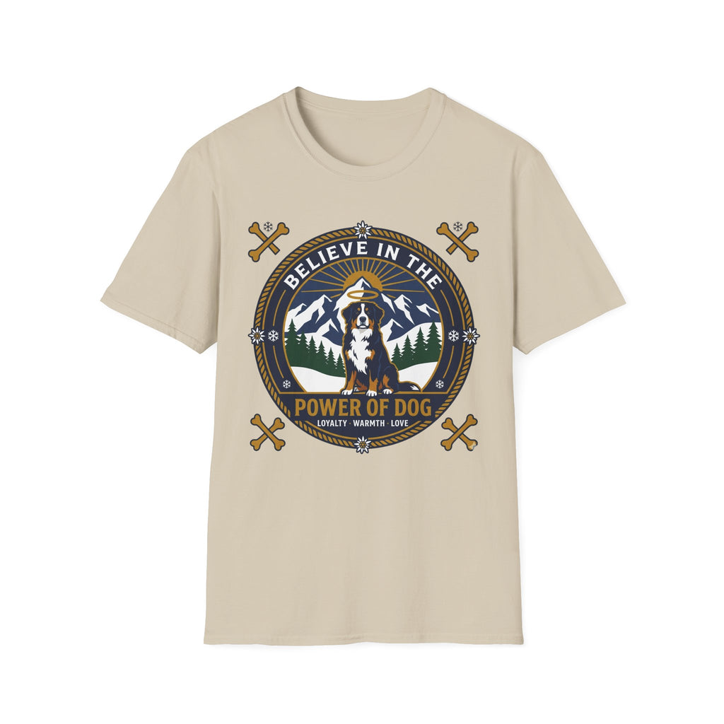 Believe in the Power of Dog Bernese T-Shirt in sand tan, flat lay view showing a circular badge graphic with a halo-wearing Bernese Mountain Dog set against a mountain and forest landscape, with crossed bones and the words 'Loyalty Warmth Love'.