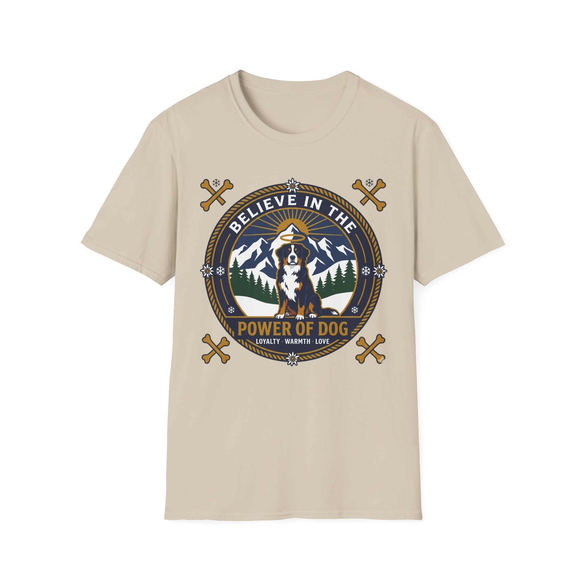 Believe in the Power of Dog Bernese T-Shirt in sand tan, flat lay view showing a circular badge graphic with a halo-wearing Bernese Mountain Dog set against a mountain and forest landscape, with crossed bones and the words 'Loyalty Warmth Love'.