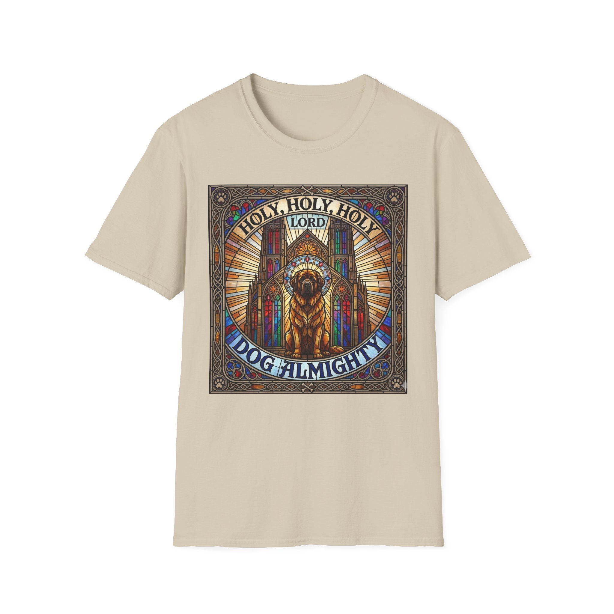 Holy Holy Holy St Bernard T-Shirt flat lay on sand, featuring a stained-glass-style illustration of a St Bernard seated before cathedral arches with the text 'Holy Holy Holy Lord Dog Almighty'.