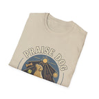 Praise Dog From Whom All Blessings Flow Labrador T-Shirt folded view in natural tan, showing the Praise Dog sunburst badge graphic with a golden Labrador at center.