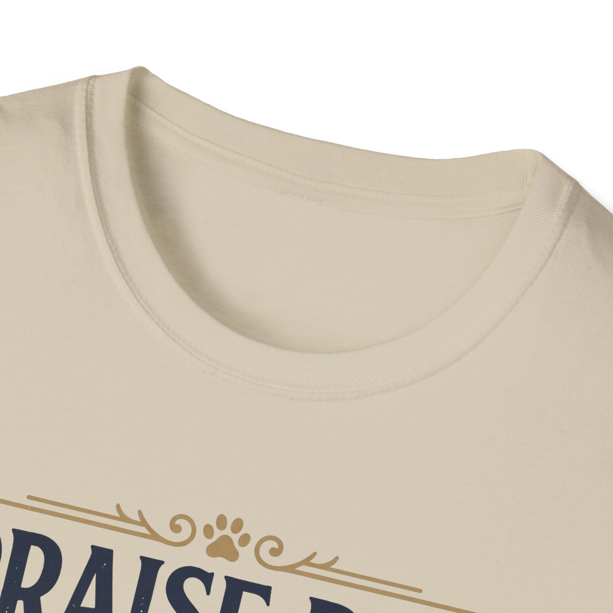 Praise Dog From Whom All Blessings Flow Golden Retriever T-Shirt close-up detail of the collar area on a natural tan shirt, showing paw print and scroll accents of the Praise Dog graphic.