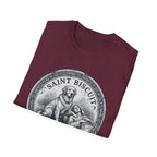 Saint Biscuit Heal Us T-shirt folded flat lay in maroon, showing the 'Saint Biscuit' medallion graphic with a golden retriever comforting a reclining figure.