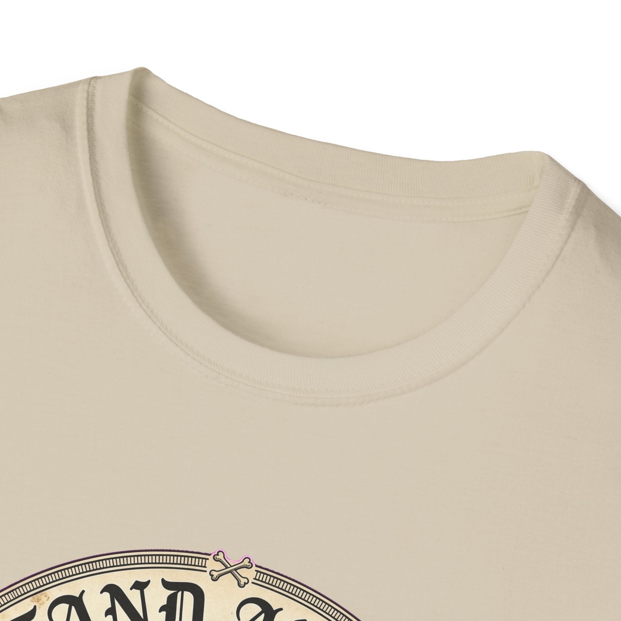 I Stand Amazed Chihuahua T-Shirt in sand, close-up of the neckline and upper graphic detail showing the circular Chihuahua design with crossed-bone medallion and vintage lettering.