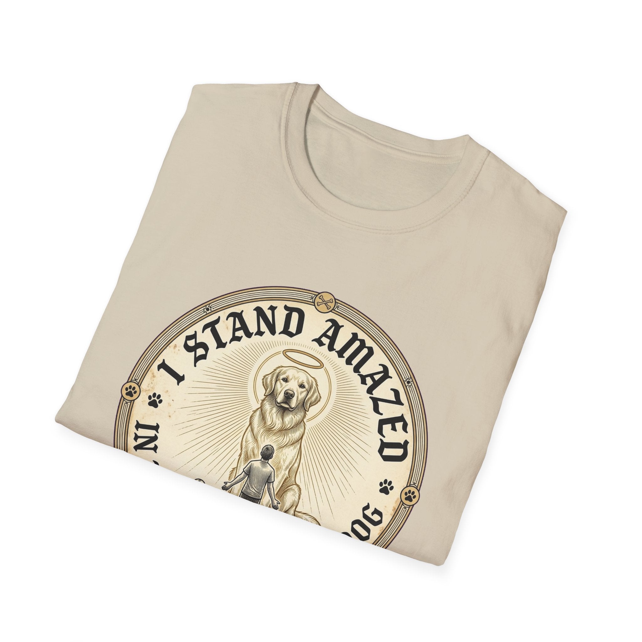 I Stand Amazed Golden Retriever T-Shirt folded view in sand, showing the golden retriever with halo graphic and "I Stand Amazed" text on the front chest.