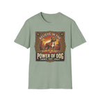 Believe in the Power of Dog Pitbull Cityscape T-Shirt in sage green, flat lay, featuring a retro-style badge graphic of a muscular brown and white Pitbull standing proudly before a warm urban cityscape at sunset, with text reading Believe in the Power of Dog and Strength, Heart, Loyalty.