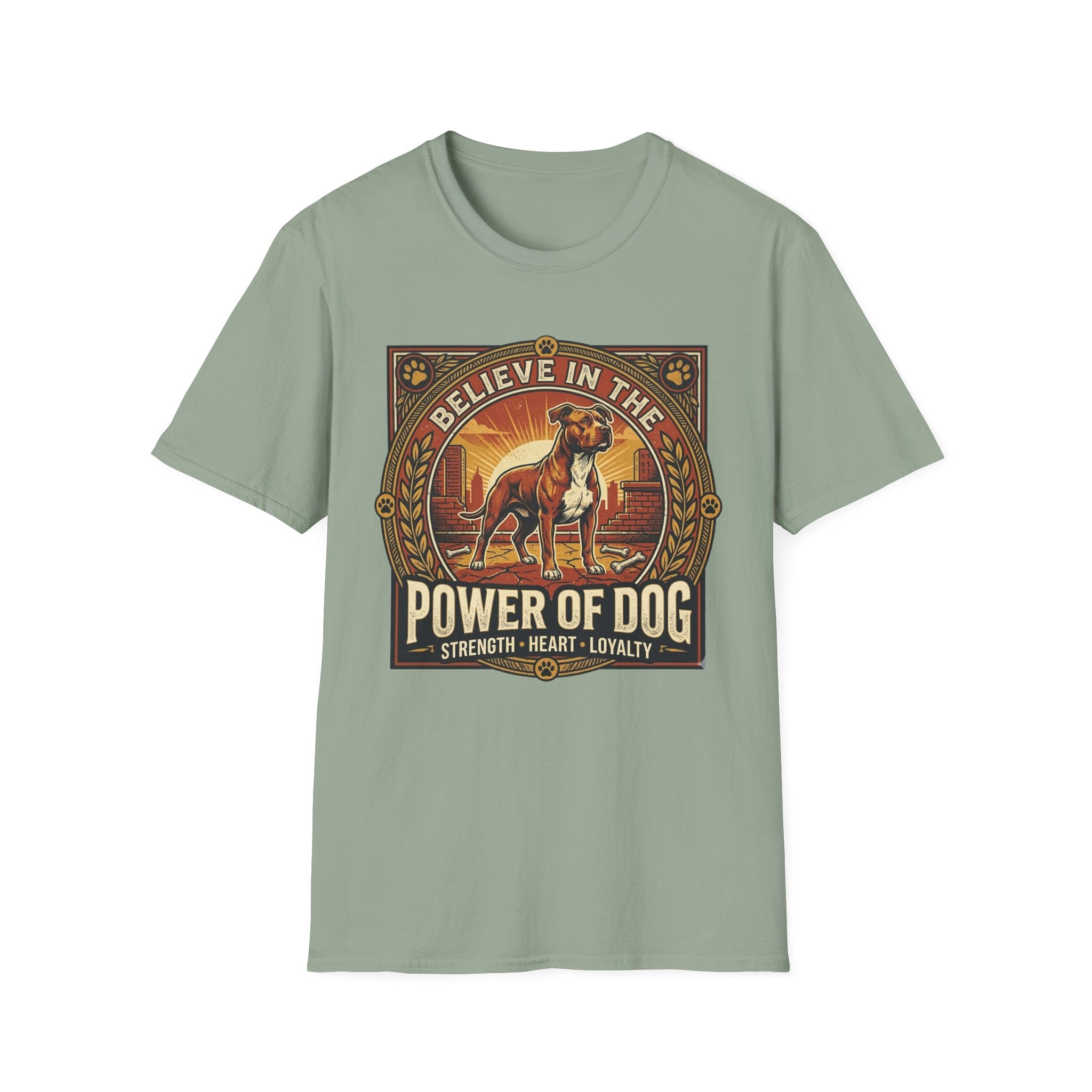 Believe in the Power of Dog Pitbull Cityscape T-Shirt in sage green, flat lay, featuring a retro-style badge graphic of a muscular brown and white Pitbull standing proudly before a warm urban cityscape at sunset, with text reading Believe in the Power of Dog and Strength, Heart, Loyalty.