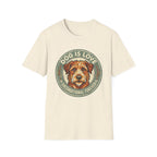 Dog is Love T-Shirt flat lay in natural/cream featuring a vintage circular badge graphic with a scruffy terrier face, "Dog is Love" arched above and "Unconditional Forever" below.