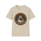 Let Go Let Dog Pug T-Shirt flat lay on sand, featuring an ornate gold-framed medallion with a halo-wearing pug raising its paws and the text 'Let Go and Let Dog'.