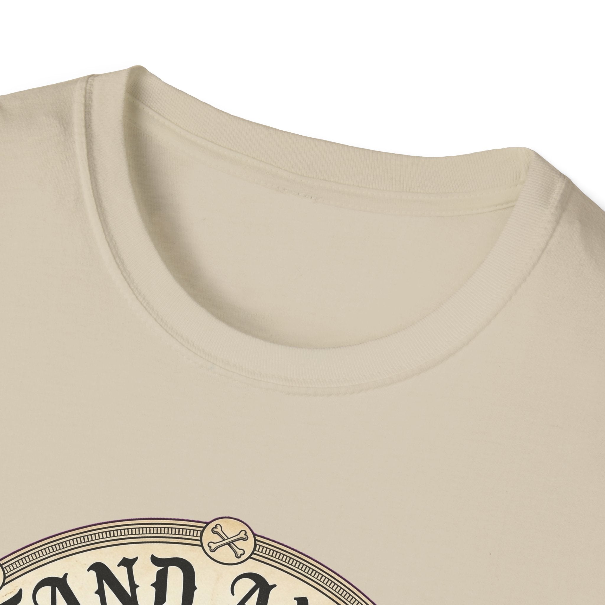 I Stand Amazed Pitbull T-Shirt in sand, close-up of the neckline and upper graphic detail showing the circular pitbull design with crossed-bone medallion and vintage lettering.