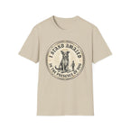 I Stand Amazed Rescue Mutt T-Shirt in sand, flat lay front view featuring a vintage-style circular graphic of a halo-wearing mixed-breed rescue dog with the text 'I Stand Amazed in the Presence of Dog.'