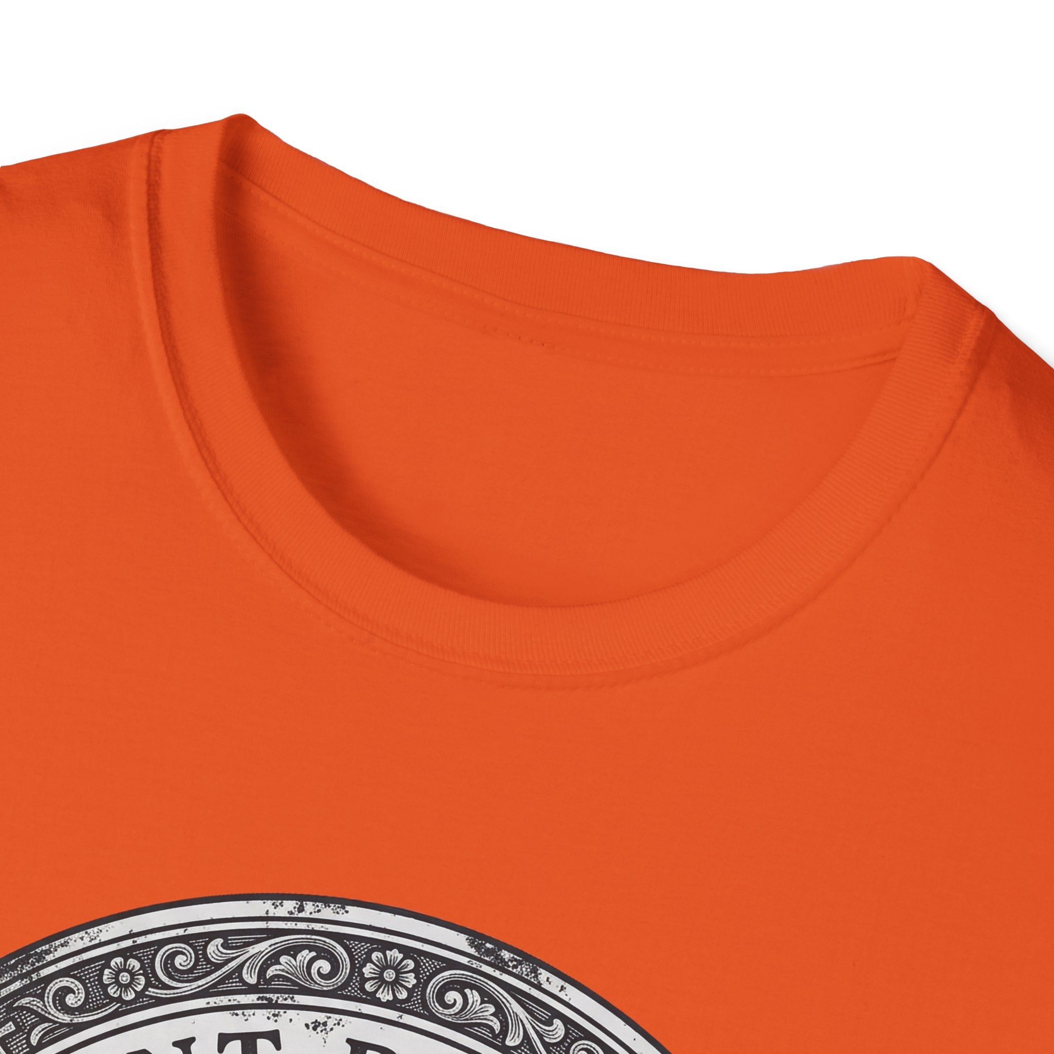 Saint Biscuit Heal Us T-shirt close-up detail on orange shirt showing the ornate circular border and 'Saint Biscuit' text of the vintage medallion graphic.