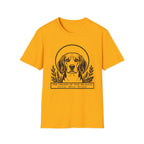 Holy Orders | Beagle T-Shirt flat lay on sage green shirt featuring a stained glass style illustration of a Beagle depicted as a holy figure with a golden halo and the text 'Holy Orders.'