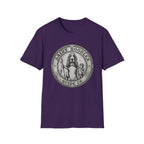 Saint Noodles Guide Us T-Shirt flat lay in purple, featuring a vintage medallion graphic of a basset hound standing upright holding a staff with a fish, alongside a small child, with the text 'Saint Noodles Guide Us'.