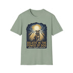 Believe in the Power Pitbull Clouds T-Shirt in sage green, flat lay, featuring a dramatic illustrated graphic of a brindle Pitbull standing before a burst of heavenly light breaking through storm clouds, with text reading Believe in the Power of Dog and Strength, Resilience, Redemption.