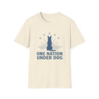 One Nation Under Dog T-Shirt flat lay in natural cream, featuring a blue dog silhouette seated before a rising sun with rays and surrounding stars, with bold text reading 'One Nation Under Dog.'