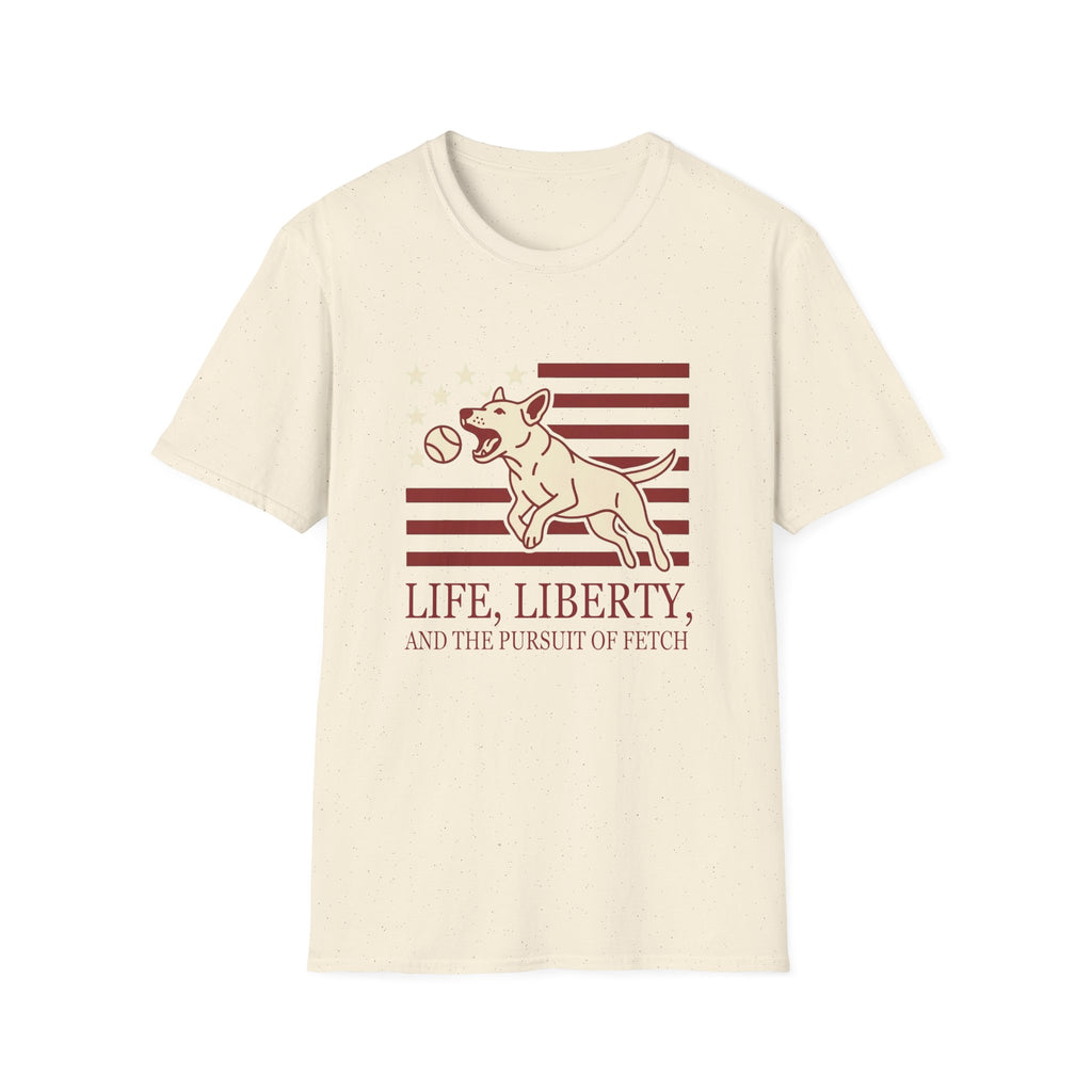 Pursuit of Fetch T-Shirt flat lay in natural cream, featuring a leaping dog catching a tennis ball over a flag of red stripes and stars, with text reading 'Life, Liberty, and the Pursuit of Fetch.'