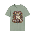 Believe in the Power of Dog Shih Tzu Throne T-Shirt in sage green, flat lay, featuring a vintage badge graphic of a fluffy white Shih Tzu seated regally on a throne surrounded by lotus flowers and mountains, with text reading Believe in the Power of Dog and Grace, Wisdom, Devotion.