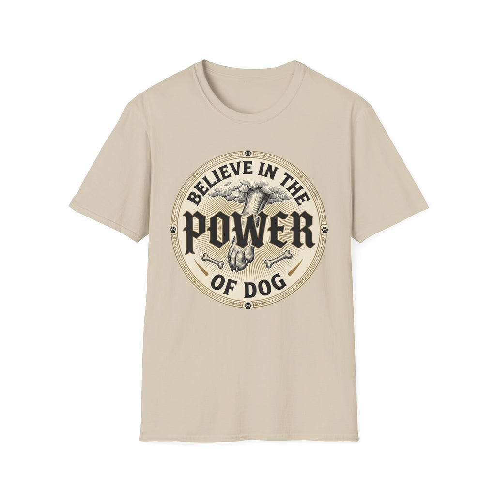 Believe in the Power of Dog Paw T-shirt flat lay in natural sand, featuring a circular vintage badge graphic of a dog paw raised like a fist from clouds above crossed bones, with paw print accents and bold text.