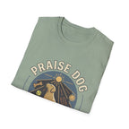 Praise Dog From Whom All Blessings Flow Labrador T-Shirt folded view in sage green, showing the Praise Dog sunburst badge graphic with a golden Labrador at center.