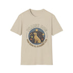 Praise Dog From Whom All Blessings Flow Labrador T-Shirt flat lay in natural tan, featuring a circular badge graphic of a golden Labrador gazing upward at a sunburst, surrounded by icons of a bone, tennis ball, paw print, and smiley face.