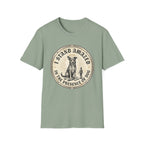 I Stand Amazed Rescue Mutt T-Shirt in sage green, flat lay front view featuring a vintage-style circular graphic of a halo-wearing mixed-breed rescue dog with the text 'I Stand Amazed in the Presence of Dog.'
