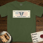In Dog We Trust Bill T-Shirt flat lay in Hemp, featuring a vintage dollar-bill design with a haloed mixed-breed Dog at center, a Betsy Ross flag in the background, and bold currency-style "In Dog We Trust" typography.