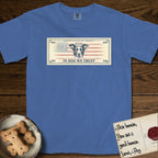 In Dog We Trust Bill T-Shirt flat lay in Mystic Blue, featuring a vintage dollar-bill design with a haloed mixed-breed Dog at center, a Betsy Ross flag in the background, and bold currency-style "In Dog We Trust" typography.