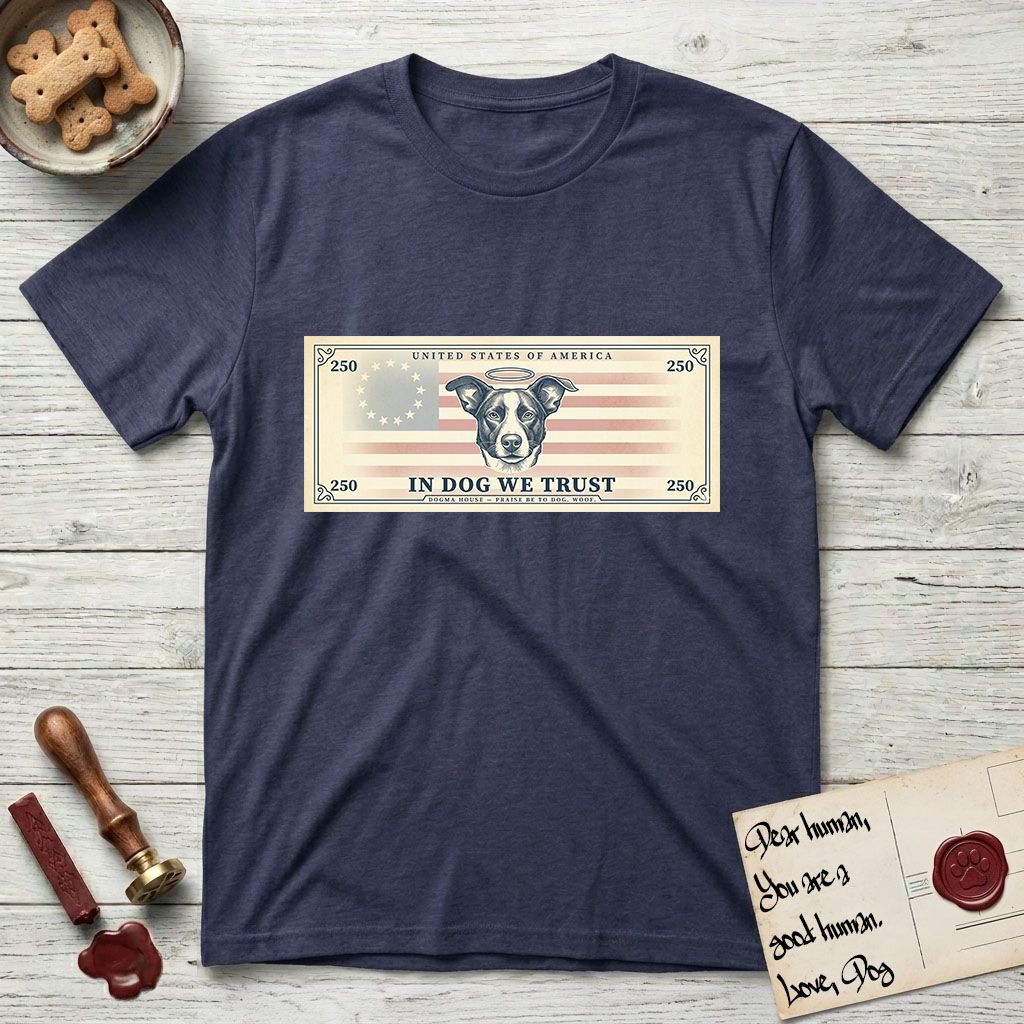 In Dog We Trust Bill T-Shirt flat lay in Navy, featuring a vintage dollar-bill design with a haloed mixed-breed Dog at center, a Betsy Ross flag in the background, and bold currency-style "In Dog We Trust" typography.