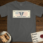 In Dog We Trust Bill T-Shirt flat lay in Pepper, featuring a vintage dollar-bill design with a haloed mixed-breed Dog at center, a Betsy Ross flag in the background, and bold currency-style "In Dog We Trust" typography.