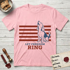 Let Freedom Ring T-Shirt flat lay in Light Pink, featuring a faded vintage-Americana line-art Beagle sitting and baying with her head thrown back in front of red flag stripes, above “Let Freedom Ring” lettering.