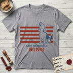 Let Freedom Ring T-Shirt flat lay in Sport Grey, featuring a faded vintage-Americana line-art Beagle sitting and baying with her head thrown back in front of red flag stripes, above “Let Freedom Ring” lettering.