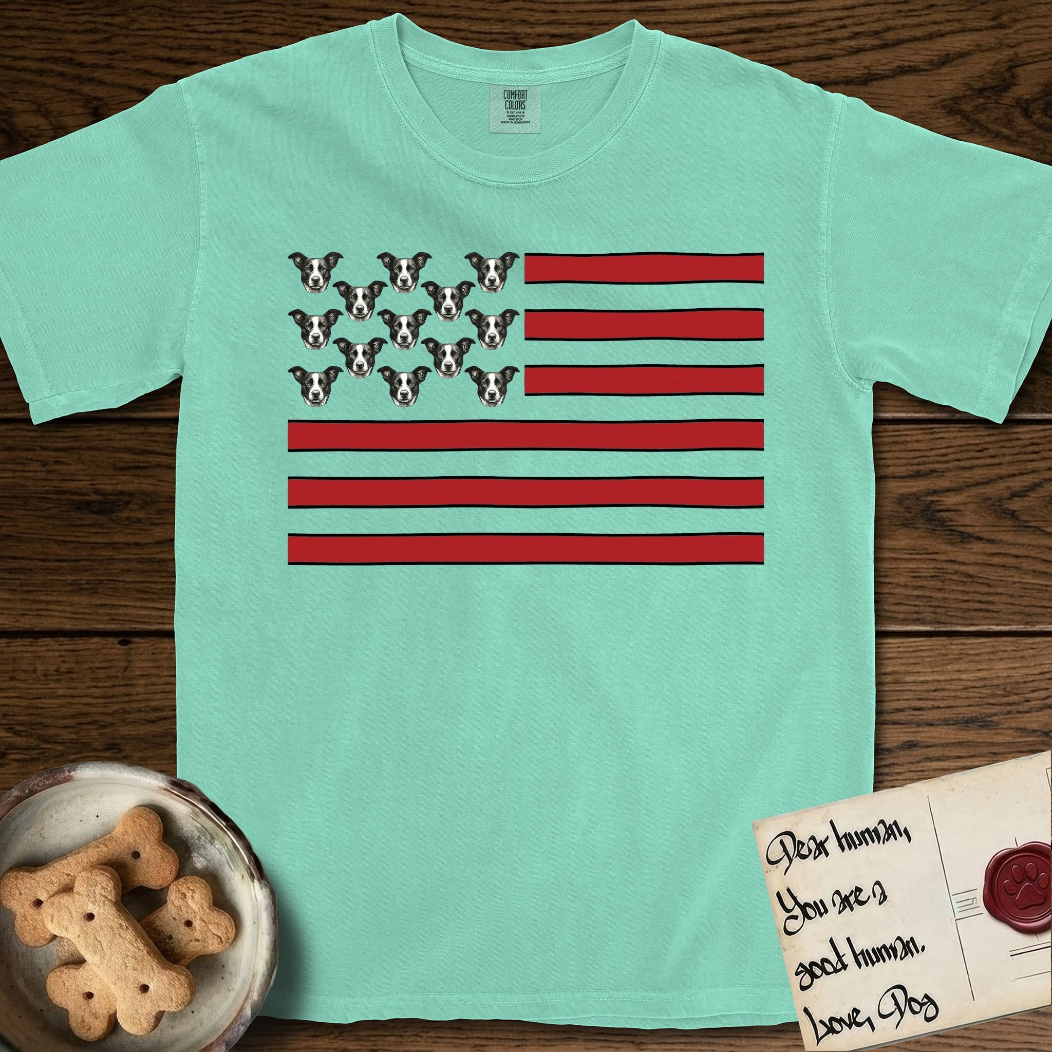 Lobo Head Flag T-Shirt flat lay in Island Reef, featuring an American flag with thirteen repeated black-and-white photos of a Pitbull-and-cattle-dog-mix Dog head in place of the stars and dusty red stripes.