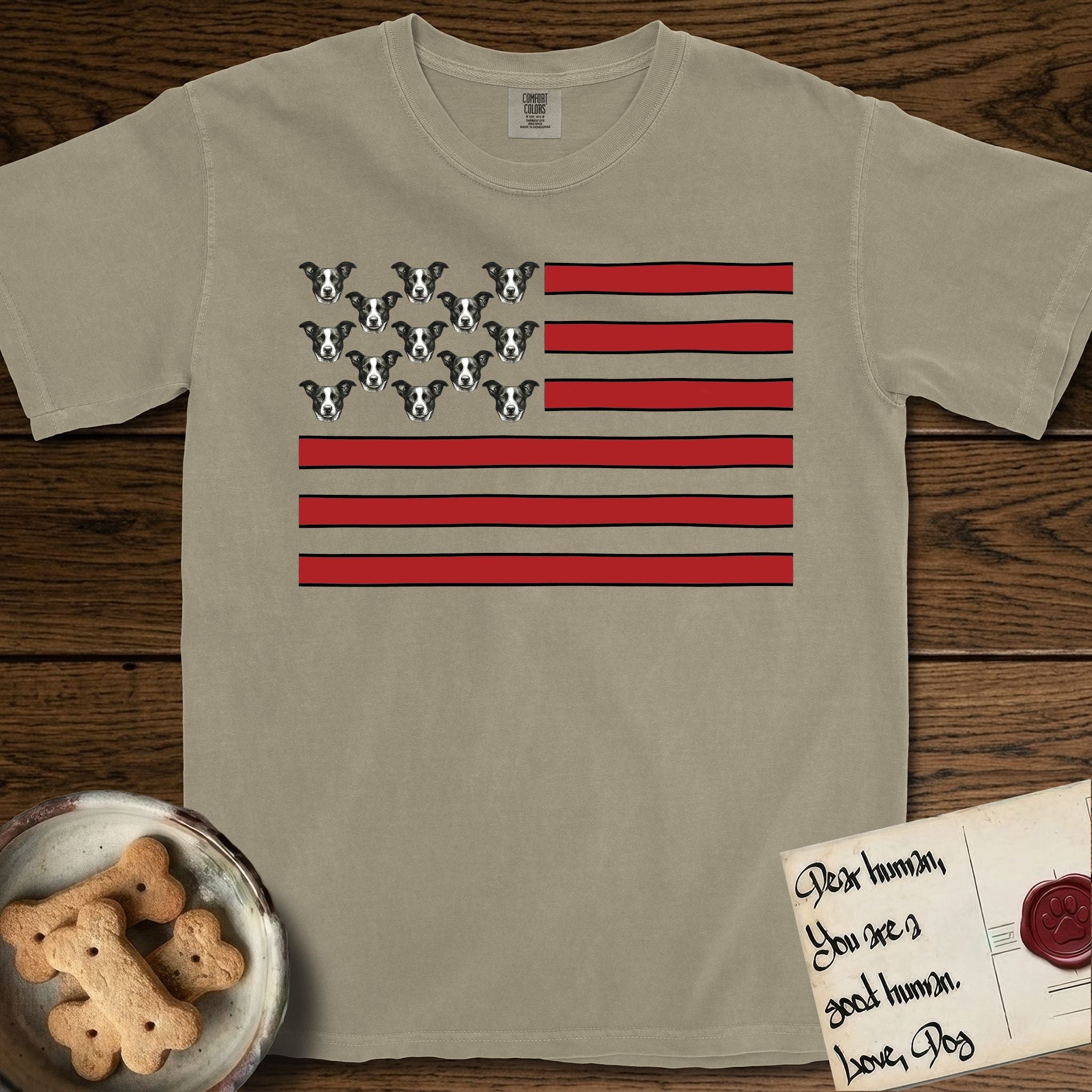 Lobo Head Flag T-Shirt flat lay in Khaki, featuring an American flag with thirteen repeated black-and-white photos of a Pitbull-and-cattle-dog-mix Dog head in place of the stars and dusty red stripes.