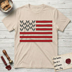Lobo Head Flag T-Shirt flat lay in Sand, featuring an American flag with thirteen repeated black-and-white photos of a Pitbull-and-cattle-dog-mix Dog head in place of the stars and dusty red stripes.