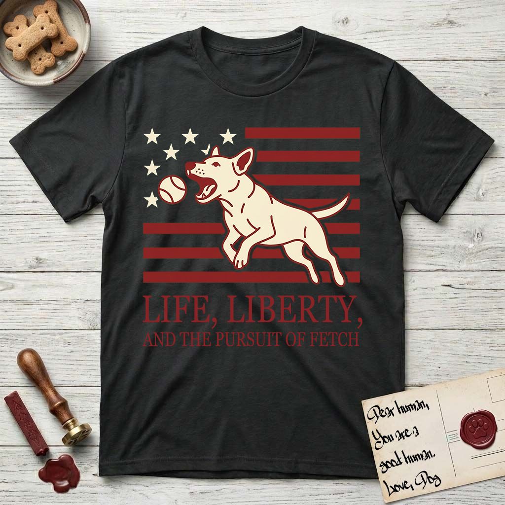 Life, Liberty, and the Pursuit of Fetch T-Shirt flat lay in Black, featuring a square flag-inspired design with a Bull Terrier leaping after a ball, cream stars, and bold "Life, Liberty, and the Pursuit of Fetch" serif typography.