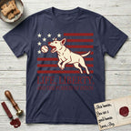 Life, Liberty, and the Pursuit of Fetch T-Shirt flat lay in Navy, featuring a square flag-inspired design with a Bull Terrier leaping after a ball, cream stars, and bold "Life, Liberty, and the Pursuit of Fetch" serif typography.