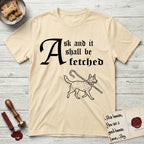 Ask and It Shall Be Fetched Australian Cattle Dog T-Shirt flat lay in Natural, featuring a sparse pen-and-ink illustration of an Australian Cattle Dog at a proud trot carrying a shepherd's crook.