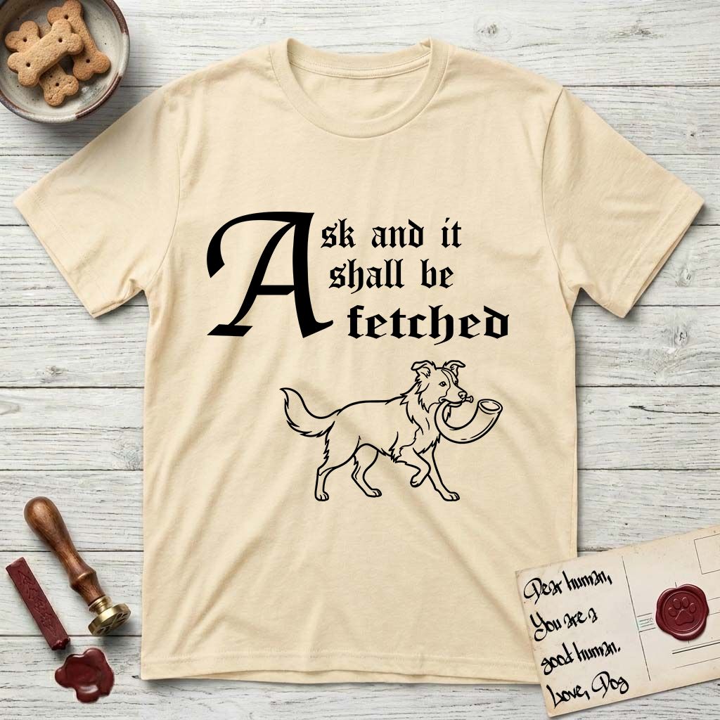 Ask and It Shall Be Fetched Border Collie T-Shirt flat lay in Natural, featuring a sparse pen-and-ink illustration of a Border Collie at a proud trot carrying a shofar.