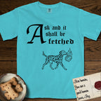 Ask and It Shall Be Fetched Dalmatian T-Shirt flat lay in Lagoon Blue, featuring a sparse pen-and-ink illustration of a Dalmatian at a proud trot carrying a small burning bush.