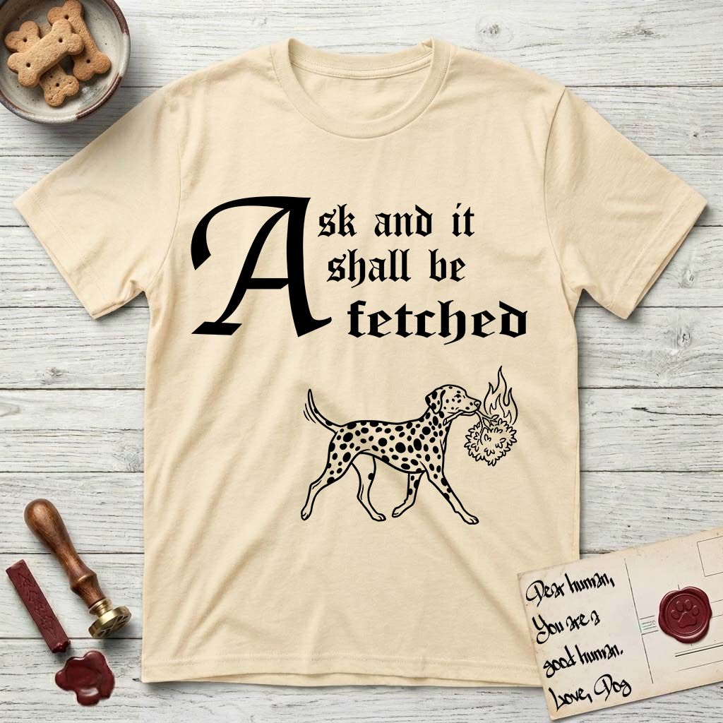 Ask and It Shall Be Fetched Dalmatian T-Shirt flat lay in Natural, featuring a sparse pen-and-ink illustration of a Dalmatian at a proud trot carrying a small burning bush.