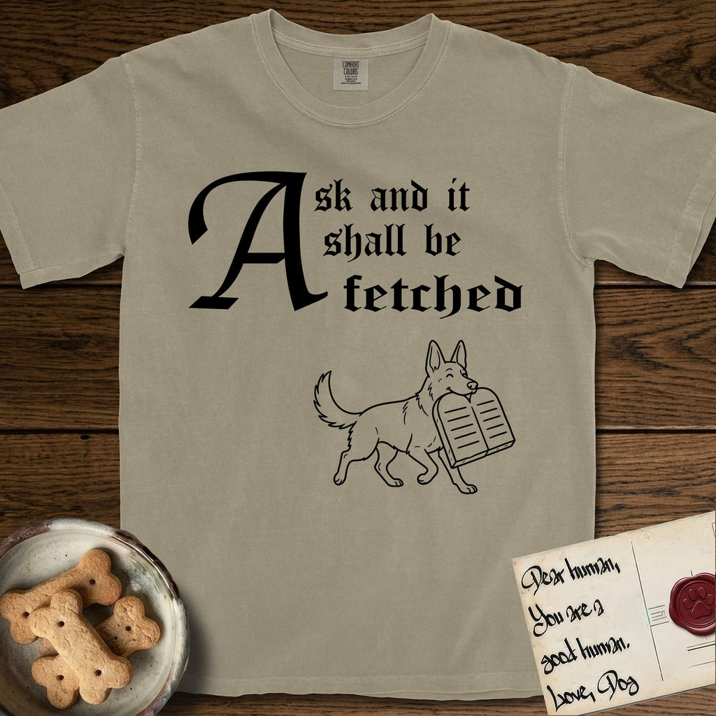 Ask and It Shall Be Fetched German Shepherd T-Shirt flat lay in Khaki, featuring a sparse pen-and-ink illustration of a German Shepherd at a proud trot carrying a pair of stone tablets.